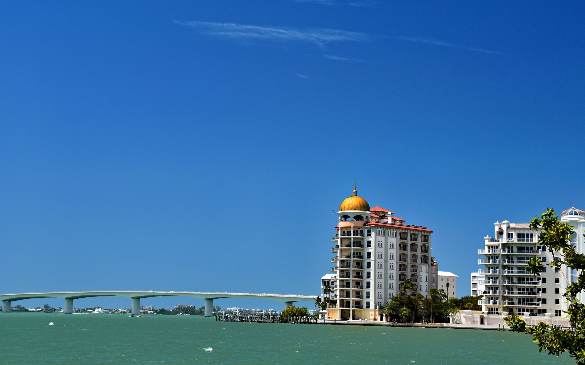 Stunning waterfront view of Sarasota's skyline and bridge under a clear blue sky.