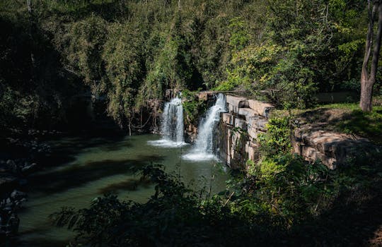 Serene waterfall cascading in the lush forests of Thailand, surrounded by vibrant greenery.