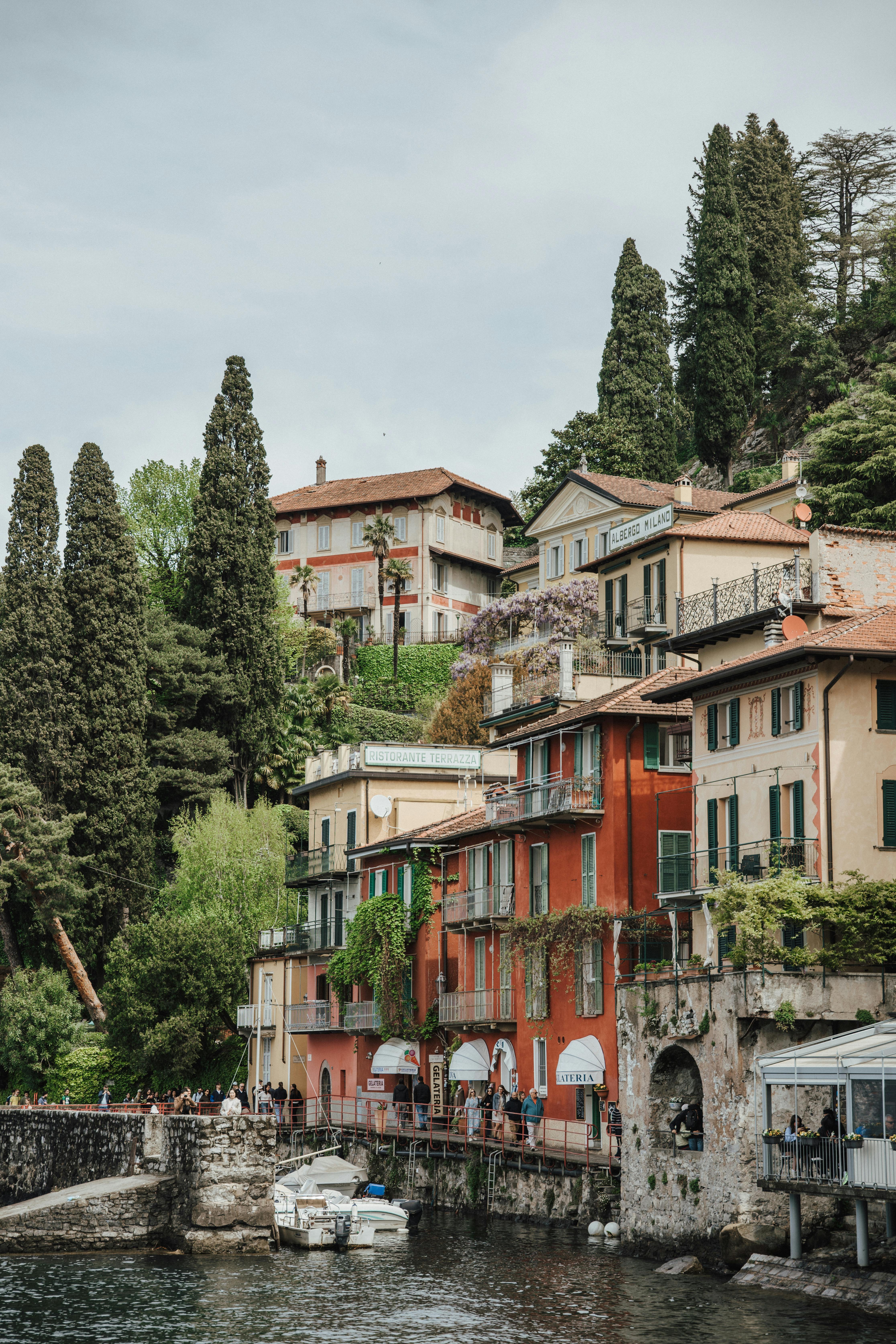 Free Picturesque view of colorful historic houses along Lake Como's waterfront in Lombardy, Italy. Stock Photo