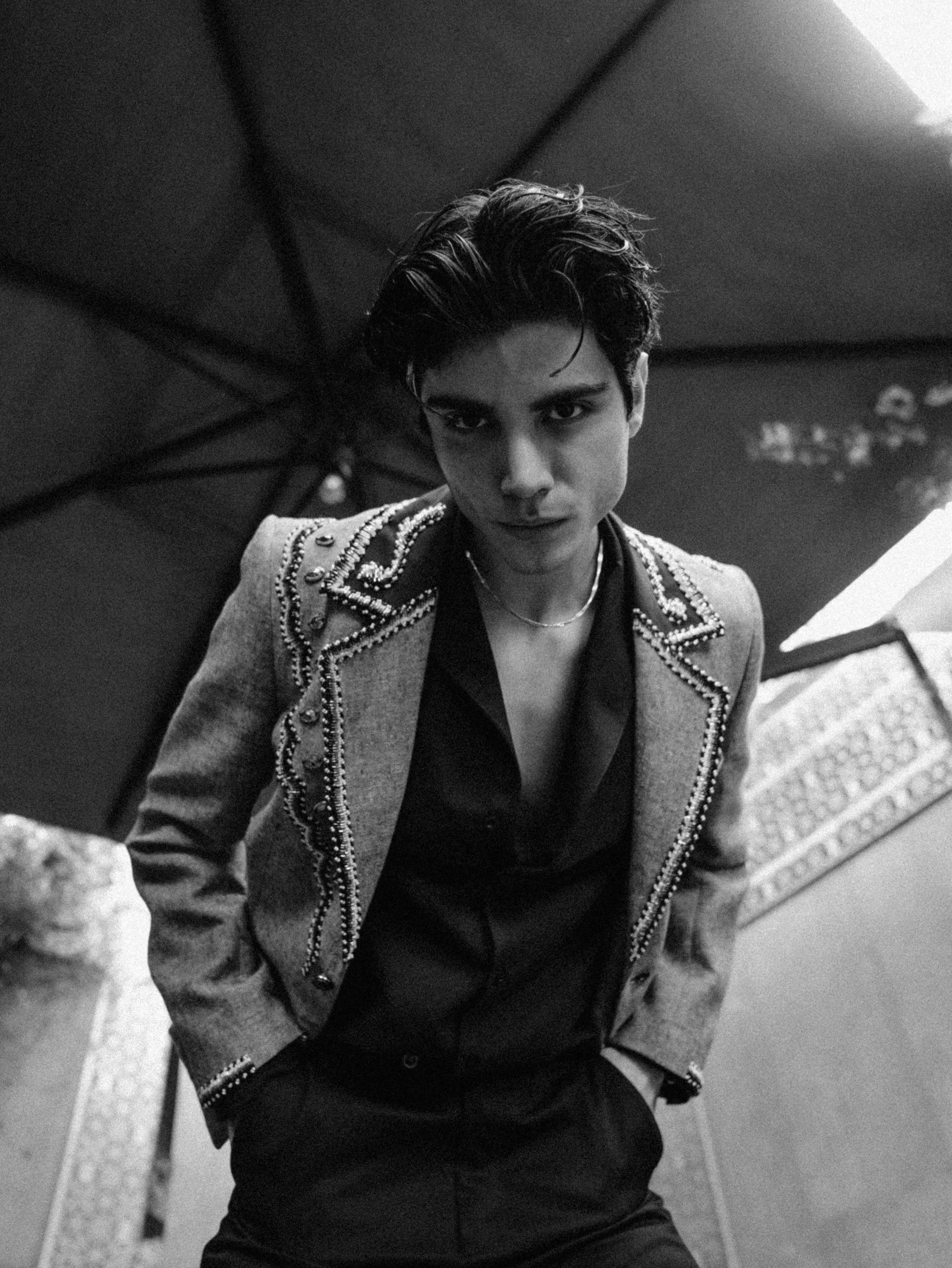 Free Black and white portrait of a stylish man wearing an embellished jacket outdoors. Stock Photo