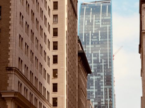 A modern skyscraper towers between historic buildings in downtown Toronto, Canada.