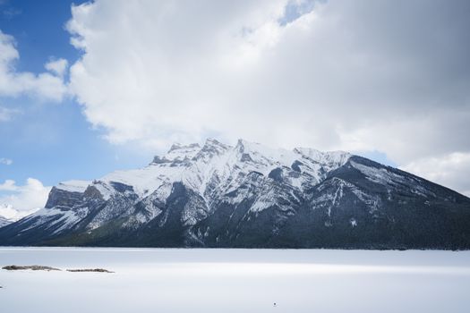 Majestic snowy mountains framed by a cloudy sky in Banff National Park.