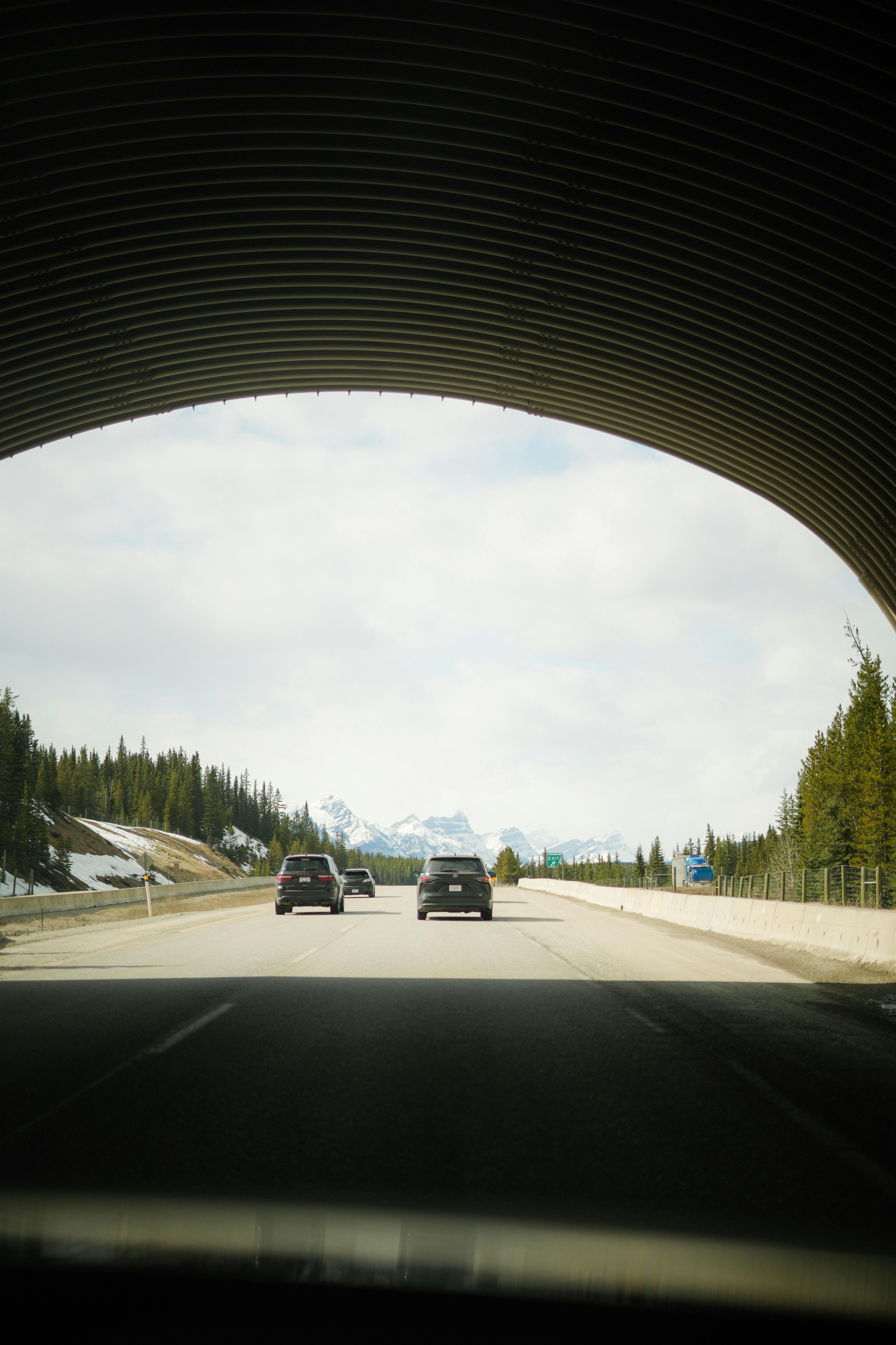 View of mountains through a tunnel on a highway, highlighting nature's beauty and travel adventure.