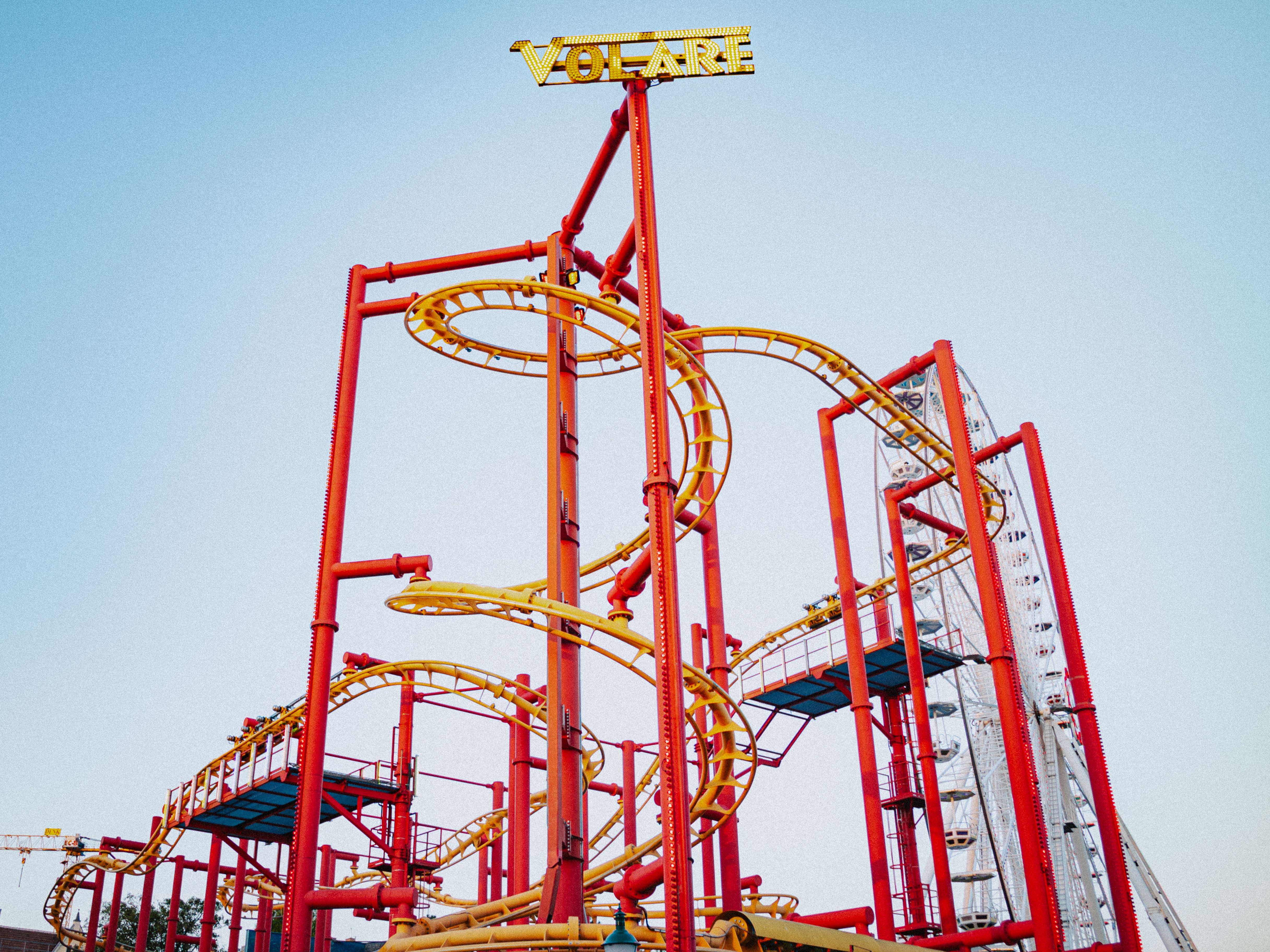 Brightly colored roller coaster at Vienna amusement park with clear blue sky backdrop.