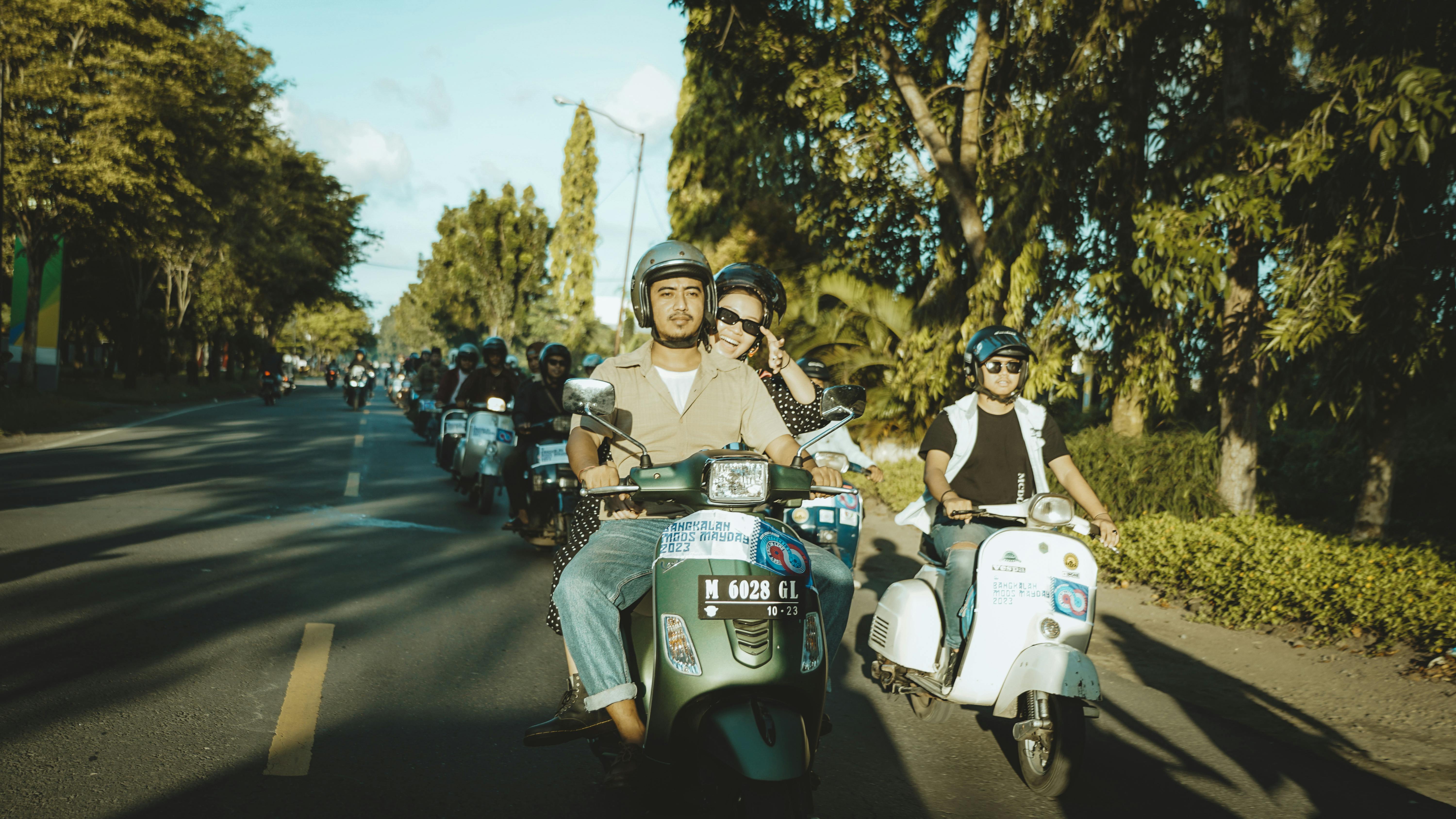 Ücretsiz Güneşli bir günde, Endonezya'nın Doğu Cava adasında manzaralı bir rotada scooter kullanan bir grup insan. Stok Fotoğraflar