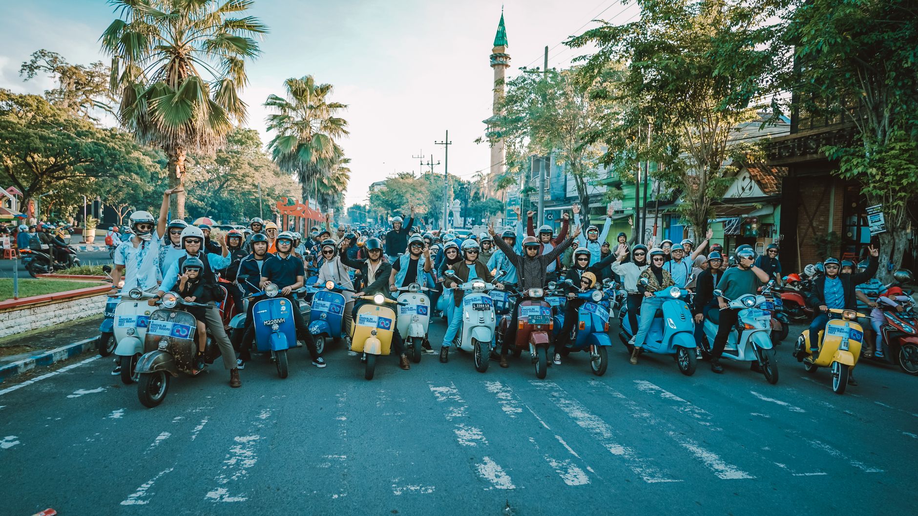 A vibrant gathering of Vespa riders enjoying a sunny day in East Java, Indonesia.