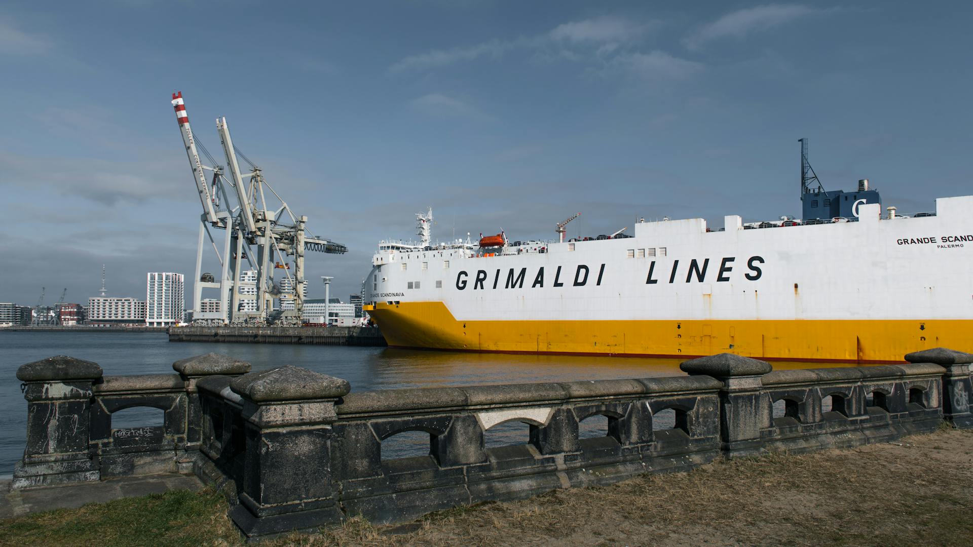 Grimaldi Lines container ship docked at Hamburg port on a clear day, showcasing global trade.