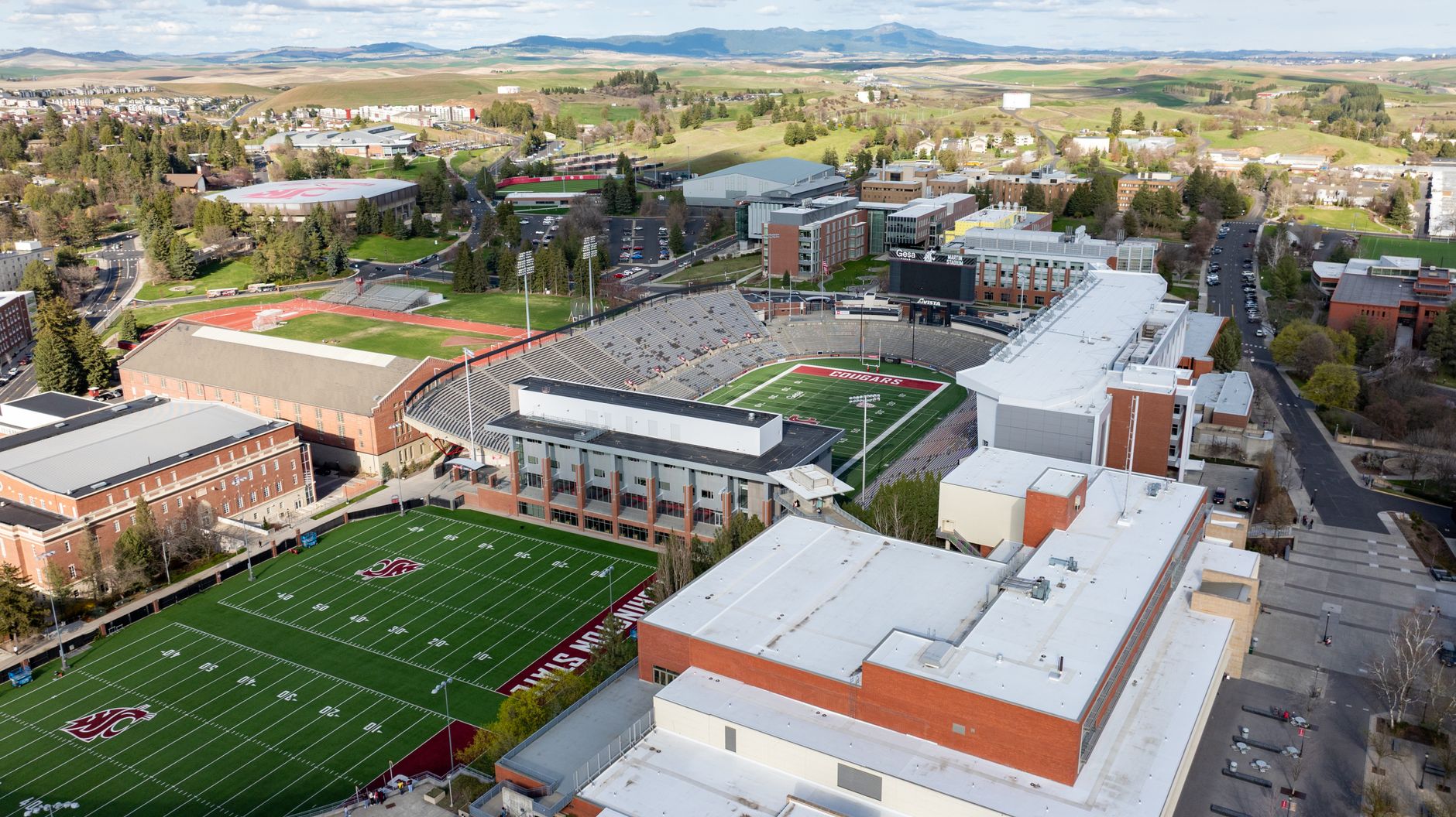 Drone shot of Washington State University campus featuring sports fields and buildings in Pullman, WA.