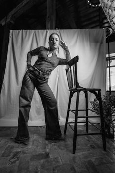 Chic black and white portrait of a woman posing in trendy fashion with a chair, Leon, Mexico.