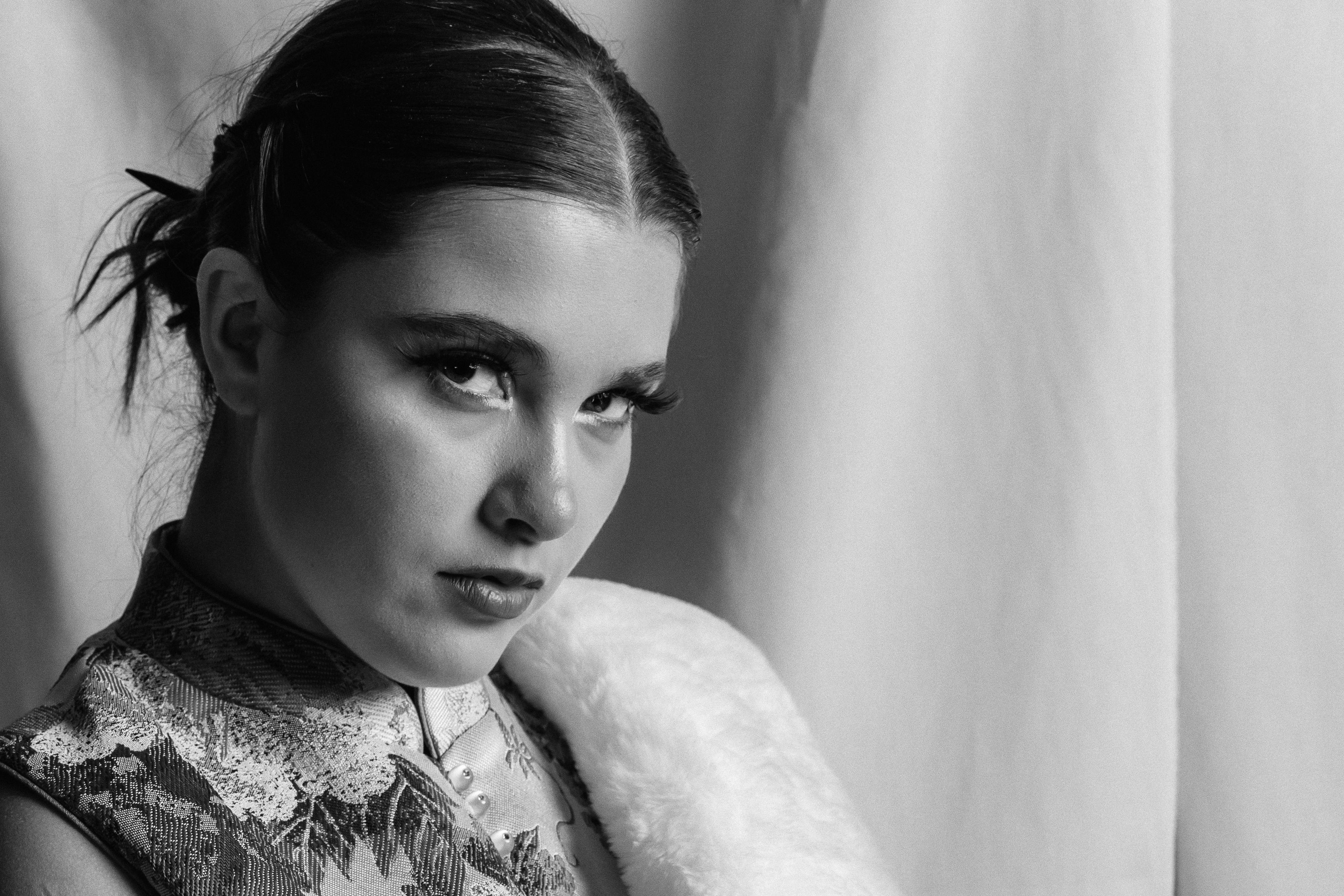 Bezpłatne Czarno-biały portret przedstawiający kobietę w stroju vintage, o niezwykłym wyrazie twarzy. Zdjęcie z galerii