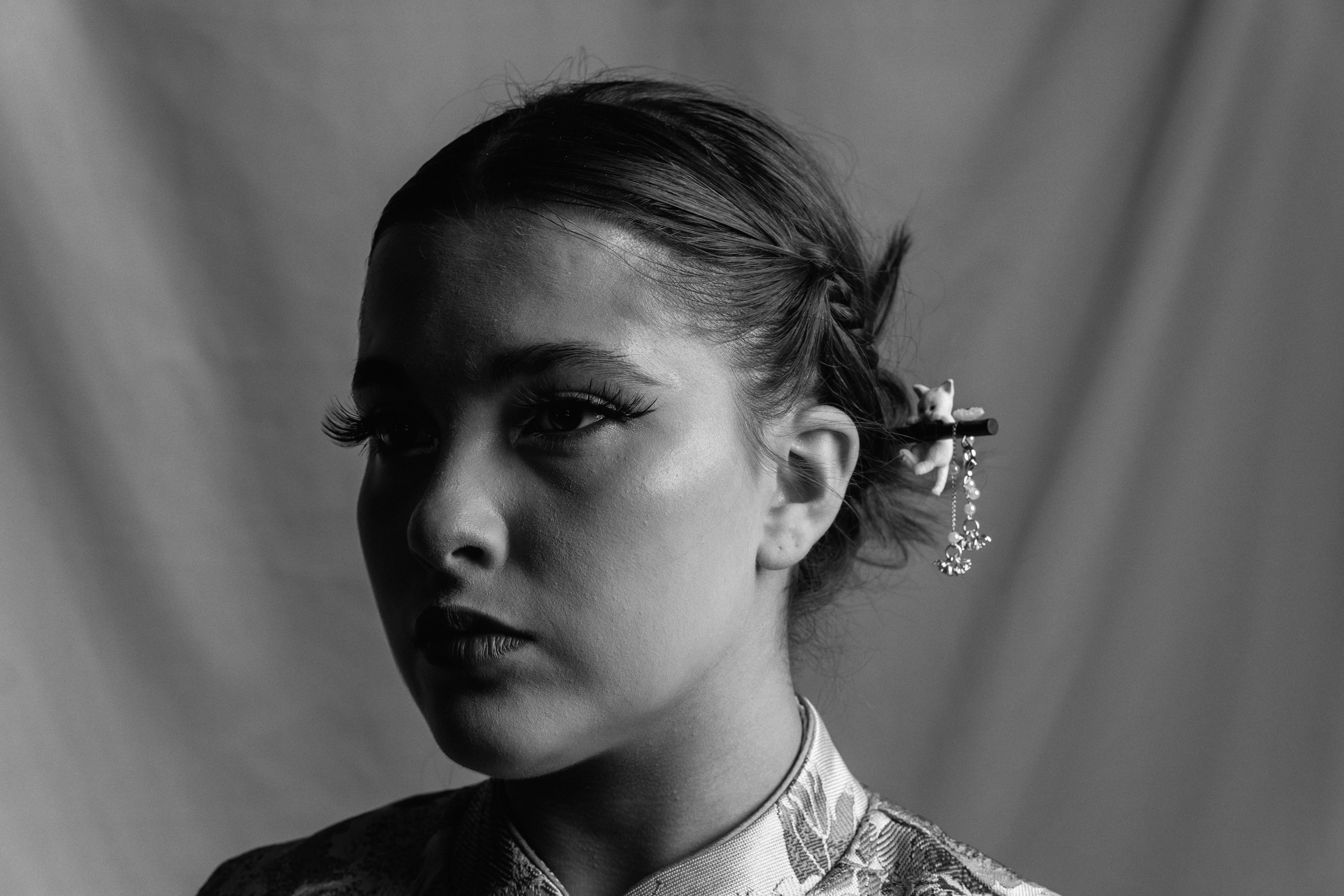 bezplatná Elegantní portrét ženy v květinovém oblečení se stylizovaným drdolem a doplňkem. Základová fotografie