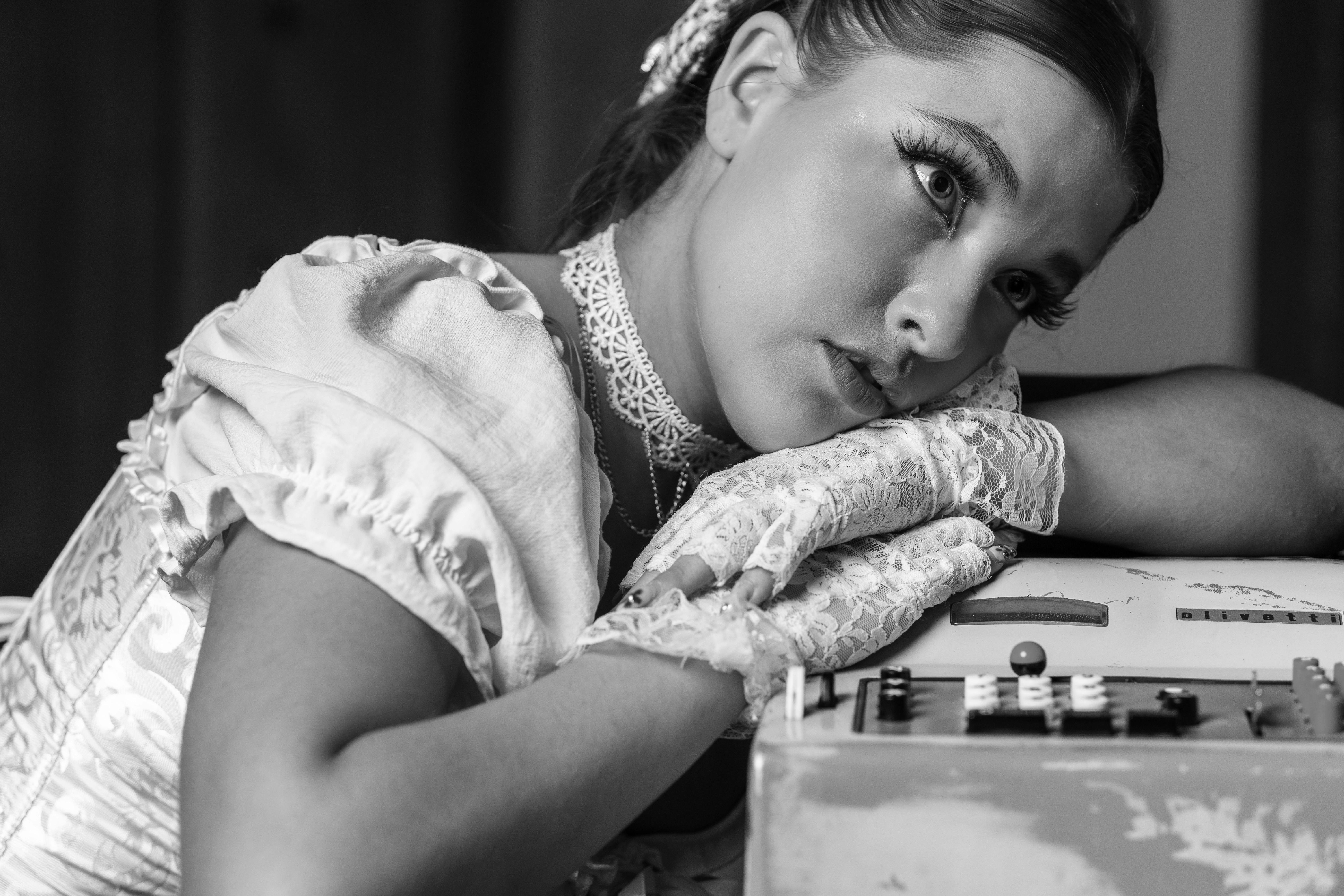 Gratis Seorang wanita bijaksana dalam pakaian vintage berpose anggun, memancarkan pesona klasik. Foto Stok