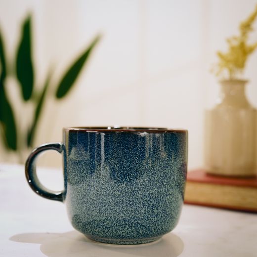 Blue reactive-glaze ceramic mug on a table — photo by Natalie Goodwin on Pexels