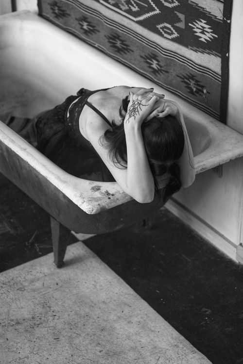 Free Elegant black and white portrait of a woman in a vintage bathtub, evoking mystery and artistry. Stock Photo