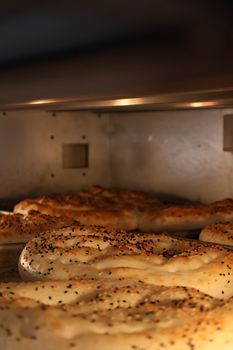 Close-up of freshly baked bread with poppy seeds in an oven.