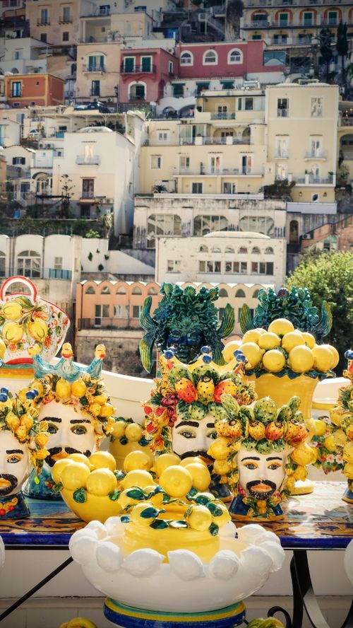 Free Colorful ceramic crafts with lemon motifs in Positano, Italy's scenic backdrop. Stock Photo