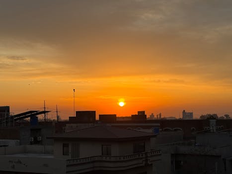 Beautiful urban sunset with vibrant orange hues illuminating the city skyline.