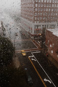 透过窗户上的飞沫，可以看见北卡罗来纳州格林斯伯勒阴雨连绵的景色，这展现了城市的氛围