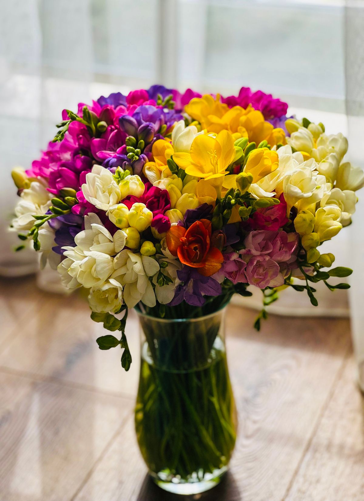 Colorful flower arrangements displayed in vases at a florist shop.