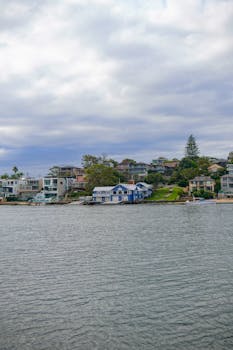 Picturesque seaside houses on a cloudy day by the waterfront, showcasing serene architecture.