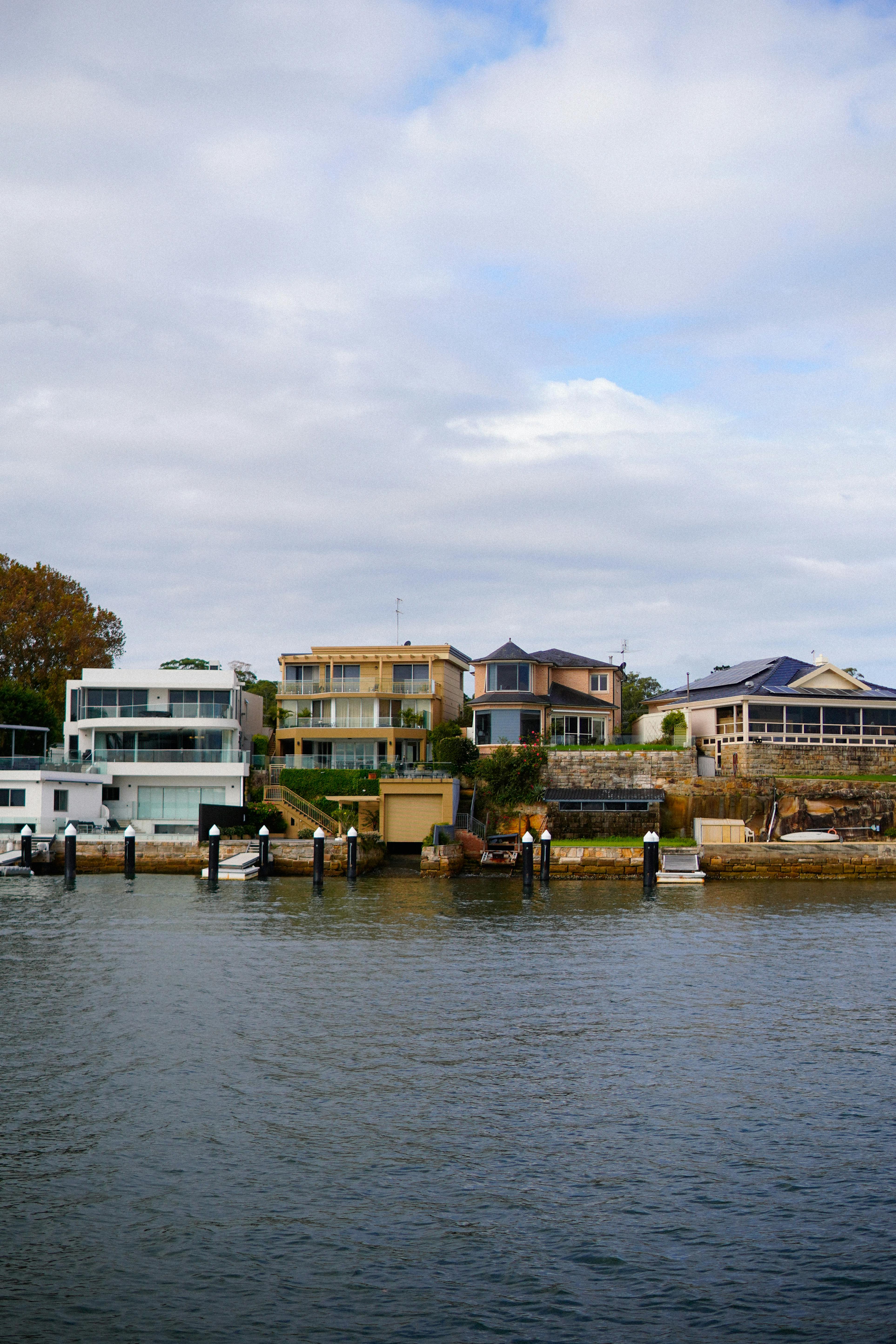 Contemporary houses line the waterfront, showcasing modern architectural designs.