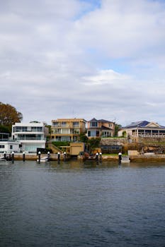 Contemporary houses line the waterfront, showcasing modern architectural designs.