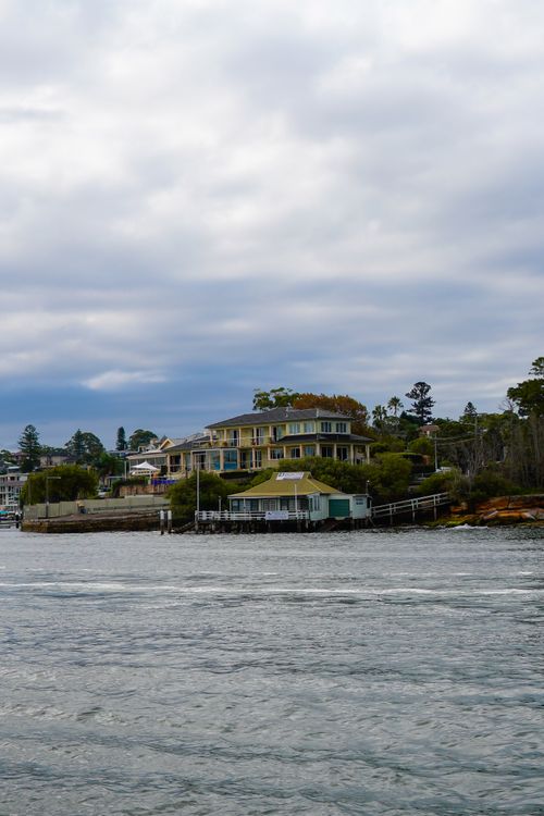 Free Elegant seaside architecture amidst a tranquil coastal setting under a cloudy sky. Stock Photo