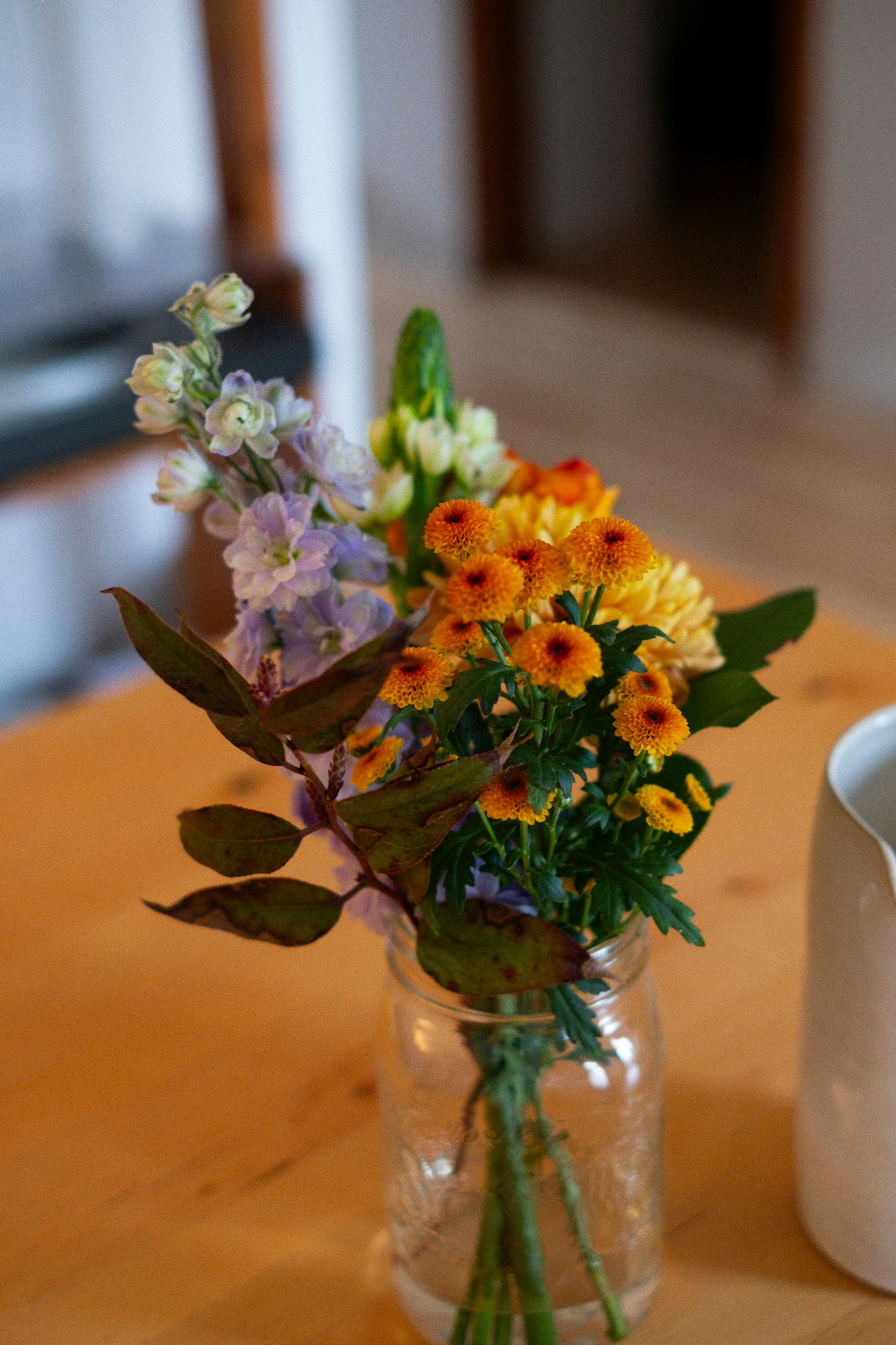 [ColoSach]-a-colorful-spring-bouquet-in-a-mason-jar-placed-on-a-warm-wooden-table,-creating-a-cozy-indoor-vibe.