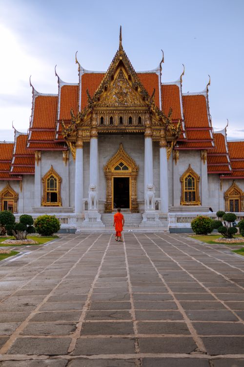 Free A Buddhist monk in front of the ornate Wat Benchamabophit temple in Bangkok, Thailand. Stock Photo