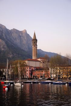 Beautiful Lecco town in Lombardy with colorful buildings, a bell tower, and mountains by the lake.