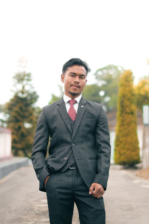 Free Confident young man in formal attire posing on a sunny day outdoors. Stock Photo