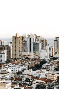 从高空俯瞰，城市景观多元，高楼耸立，天空晴朗
