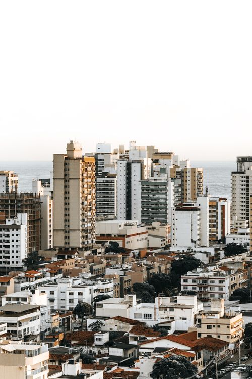 Free Aerial view of a diverse cityscape with towering high-rises and urban architecture against a clear sky. Stock Photo