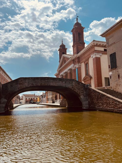 Free Historic Italian canal with scenic bridge on a sunny day, showcasing charming architecture. Stock Photo