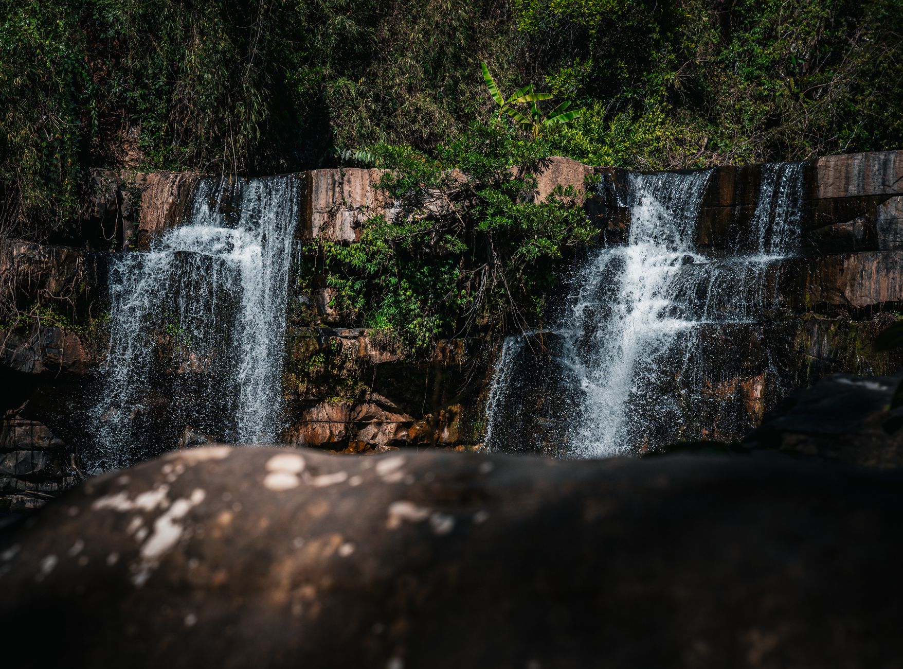 Discover the beauty of a cascading waterfall in Thailand's vibrant jungle landscape.