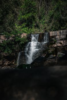 Beautiful forest waterfall cascading in Thailand amid lush greenery.