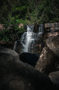 A captivating waterfall in the Thai forest with lush green surroundings and cascading water.