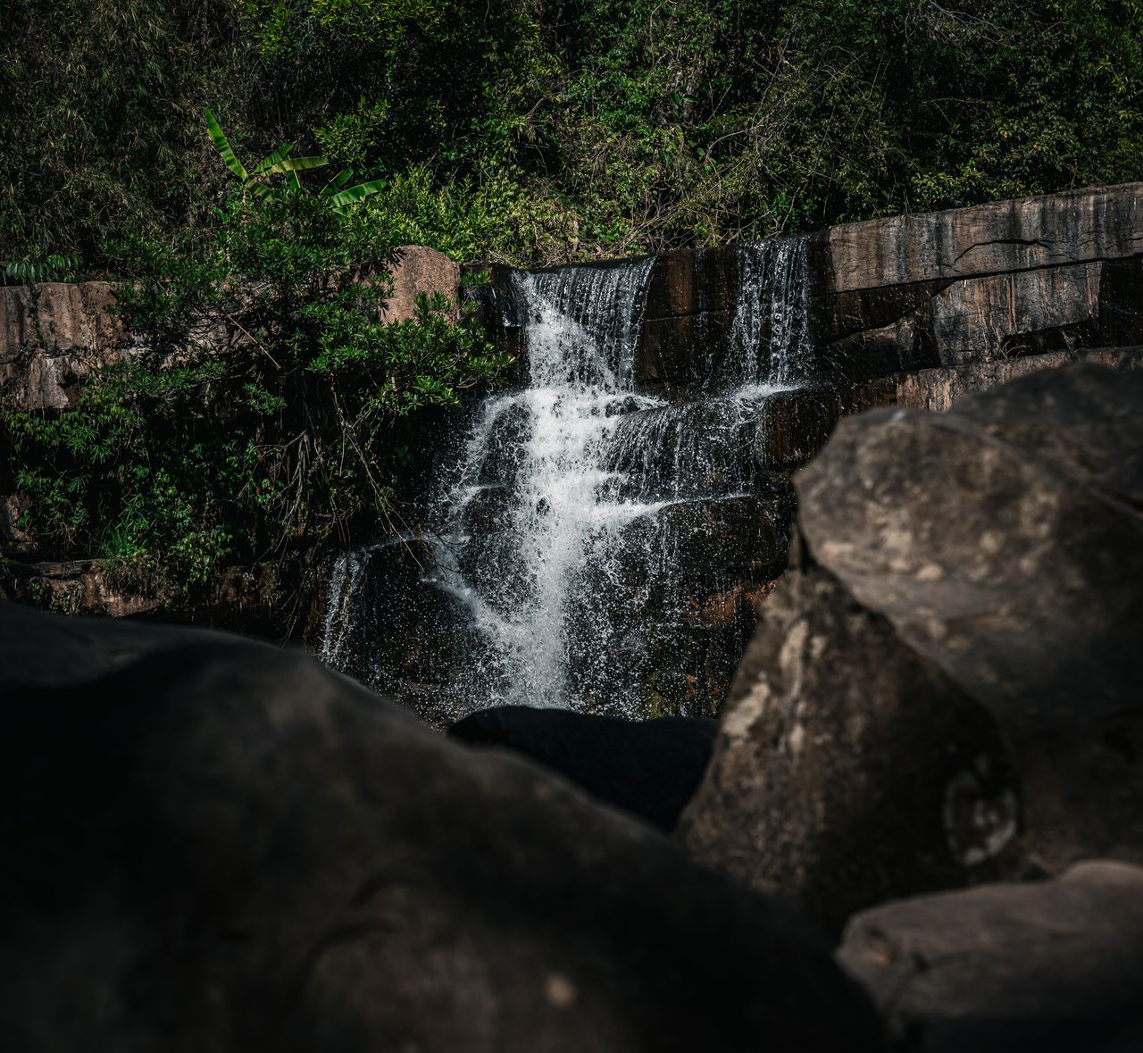 a beautiful waterfall cascading amidst lush greenery in thailand ideal