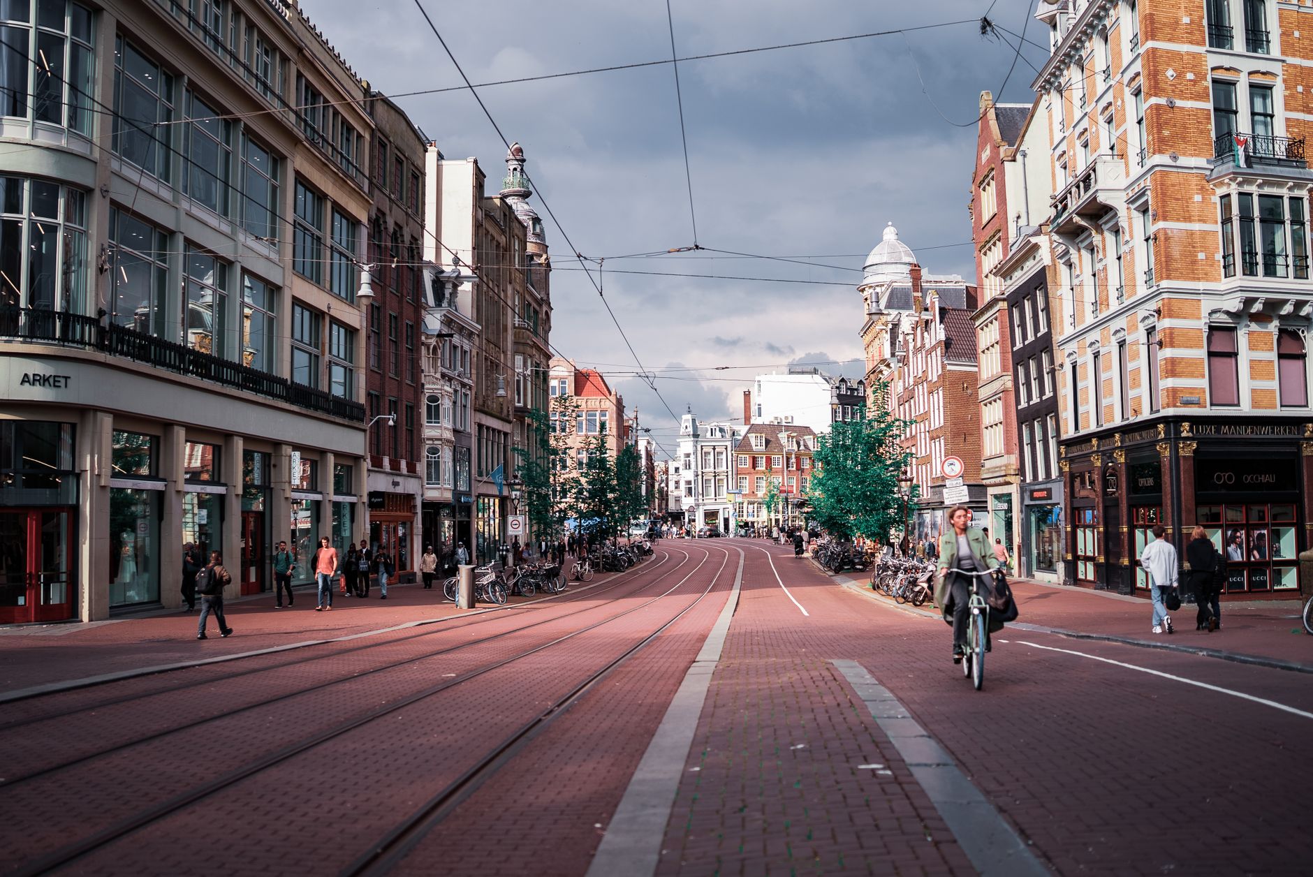 Een schilderachtig straatbeeld in Amsterdam met de levendige architectuur en een fietser op een heldere dag.