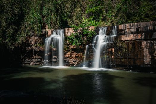 Breathtaking view of a waterfall cascading in a lush forest in Thailand, capturing the essence of untouched nature.