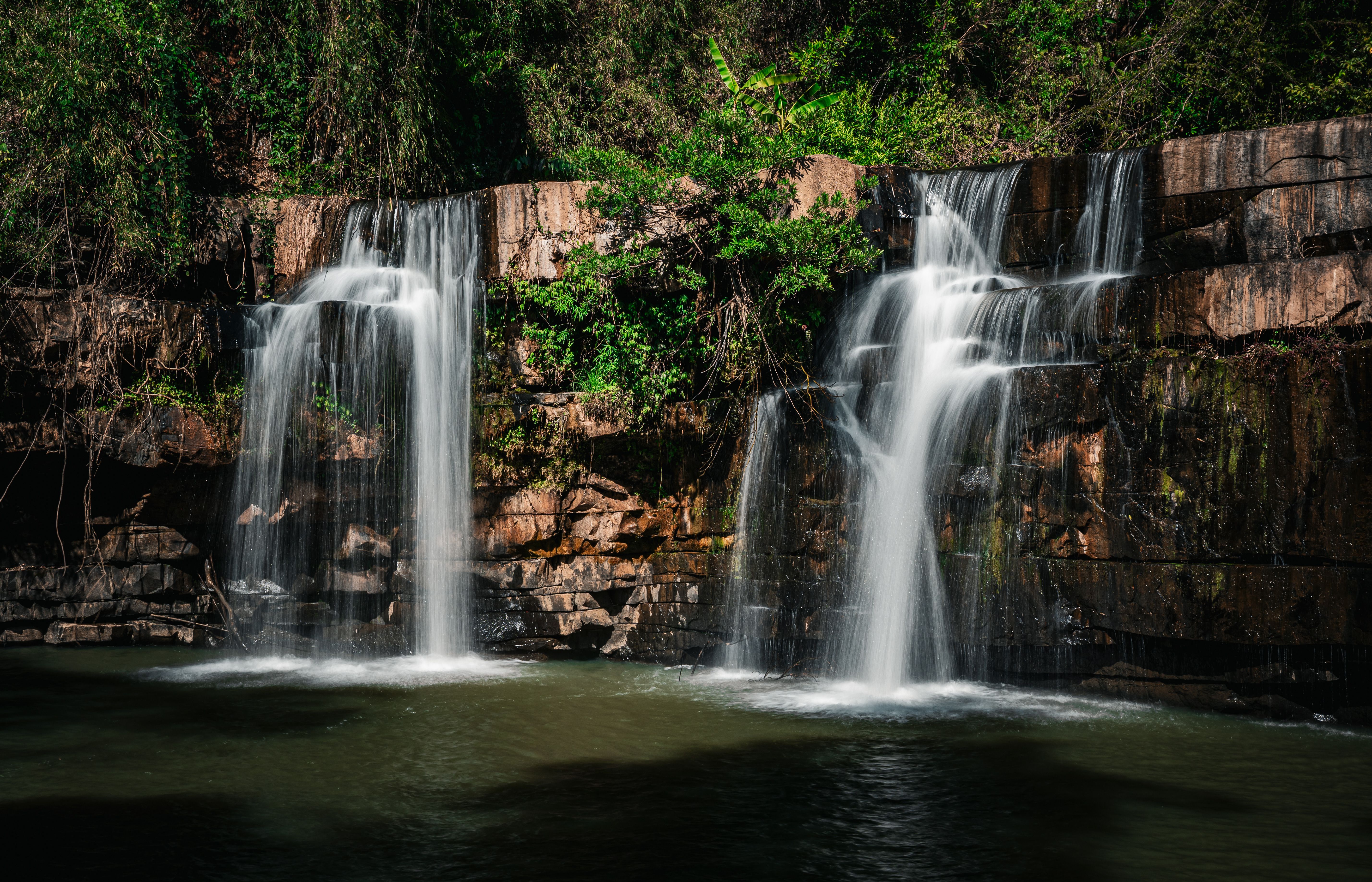 A stunning cascading waterfall surrounded by lush greenery in Thailand's serene forest.