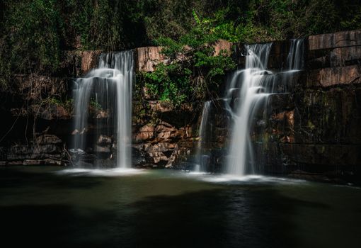 Explore a breathtaking waterfall cascading through Thailand's vibrant forest landscape.
