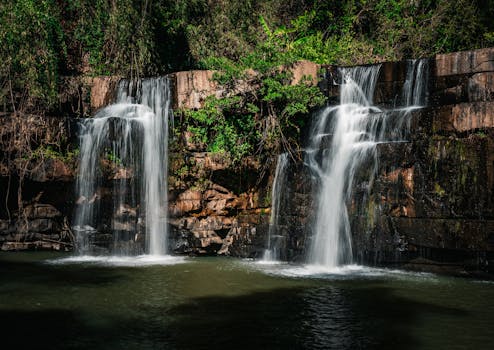 Majestic waterfall cascades in Thailand's vibrant jungle setting, capturing nature's beauty.