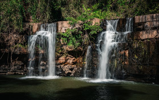 A serene waterfall cascading over rocks in the lush forest of Thailand.
