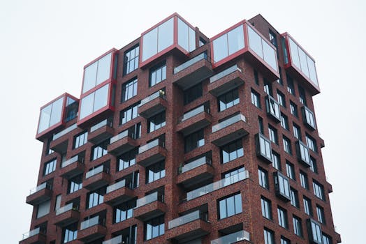 Unique red-brick apartment building with striking design in an urban setting.
