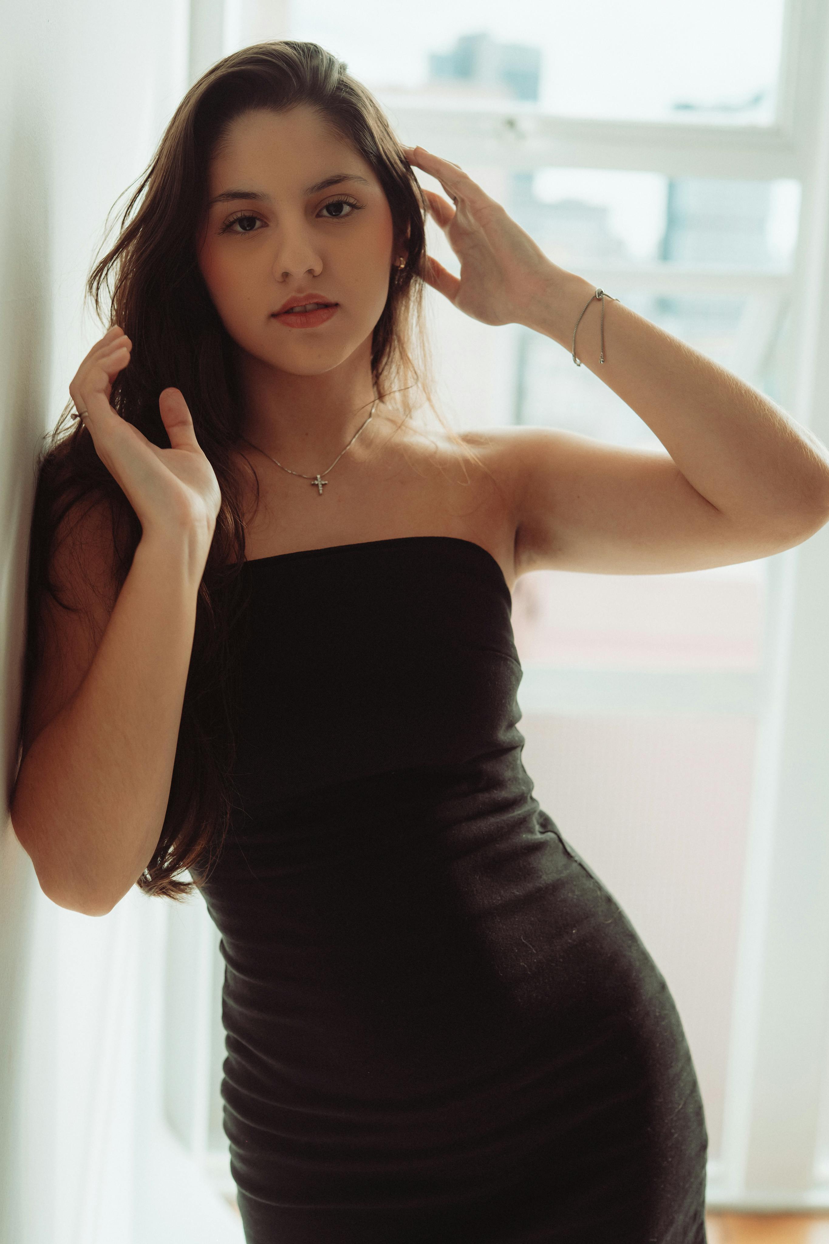 Stunning portrait of a woman in a black dress by a window in Curitiba, Brasil.
