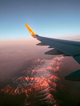 Aerial view from airplane window showing picturesque Bodrum mountains at sunset.