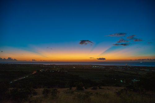 Free A breathtaking sunset over a coastal landscape with vivid sky colors and a serene horizon view. Stock Photo