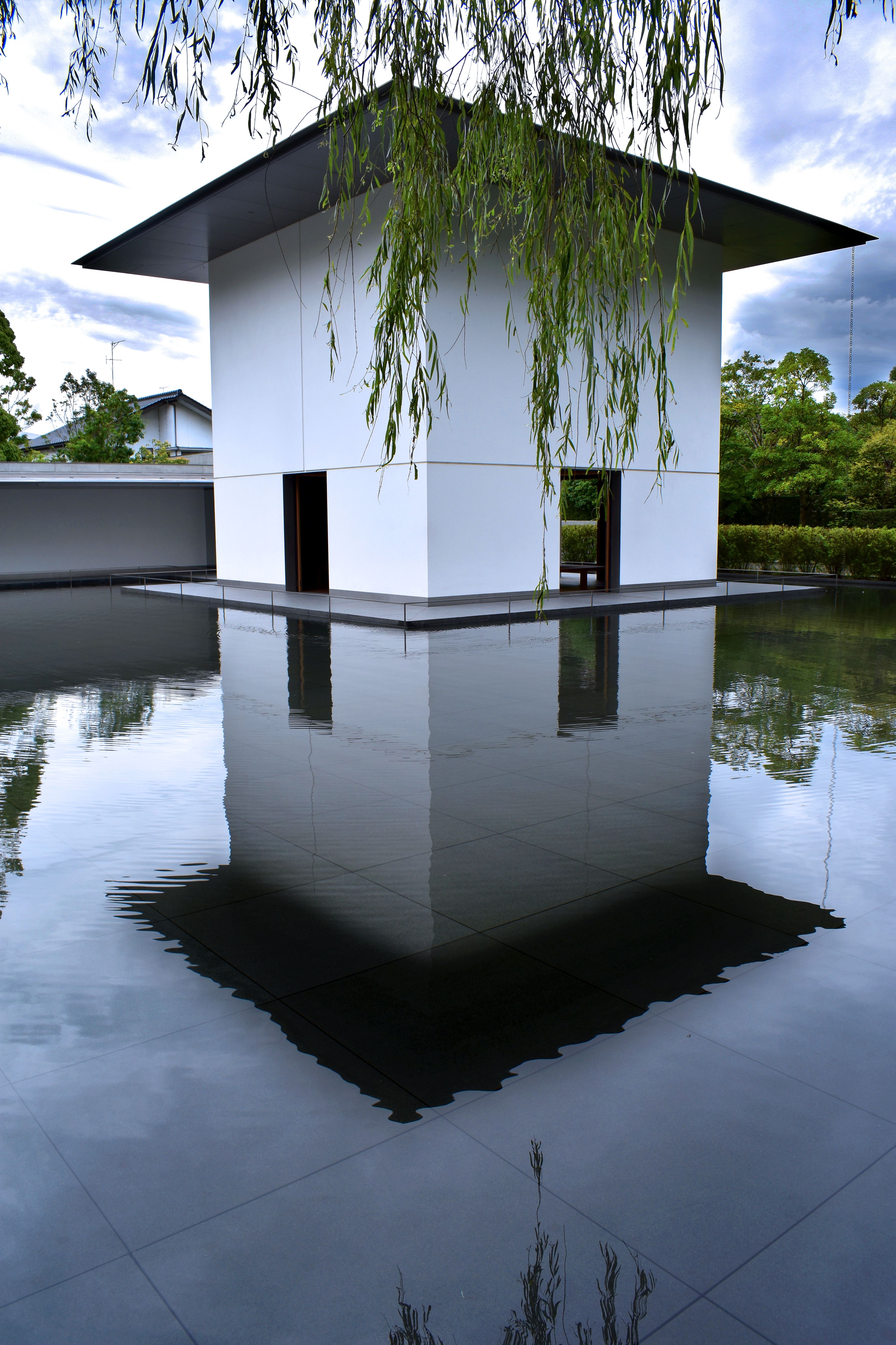 A serene minimalist structure reflected in a tranquil water garden, Kanazawa, Japan.