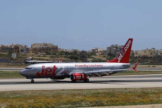 Jet2 airplane on the runway with buildings in the background on a sunny day.